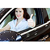 Attractive young woman sitting in car in car center