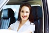 Attractive young woman sitting in car in car center