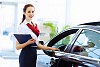 Young attractive woman consultant of car center standing near car