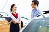 Young man choosing car at salon with help of consultant