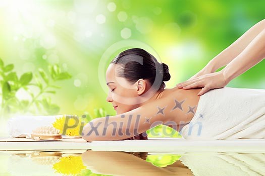 Young pretty woman with clear skin at spa salon getting massage