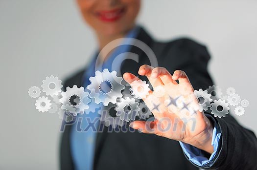 Image of businesswoman touching gear elements. Mechanism concept Image of businesswoman touching gear elements. Mechanism concept