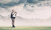 Pretty young woman tourist standing on top of mountain