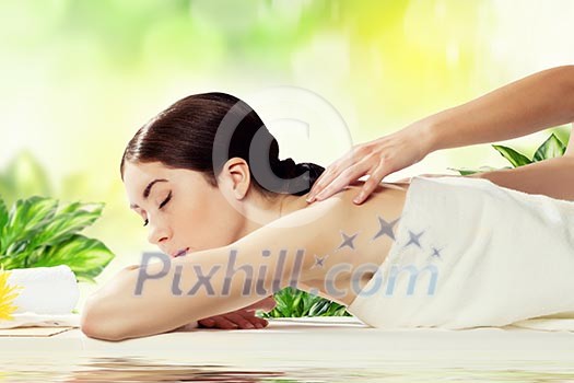 Young pretty woman with clear skin at spa salon getting massage