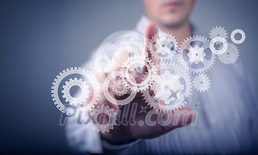 Image of businessman touching gear elements. Mechanism concept Image of businessman touching gear elements. Mechanism concept