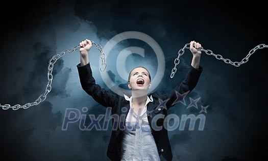 Image of businesswoman in anger breaking metal chain Image of businesswoman in anger breaking metal chain