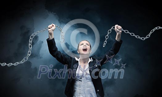 Image of businesswoman in anger breaking metal chain