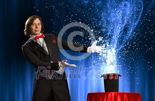 Image of magician holding hat with lights and fumes going out