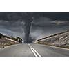 Image of powerful huge tornado twisting on road