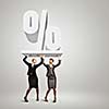 Image of two businesswomen holding percentage symbol above head