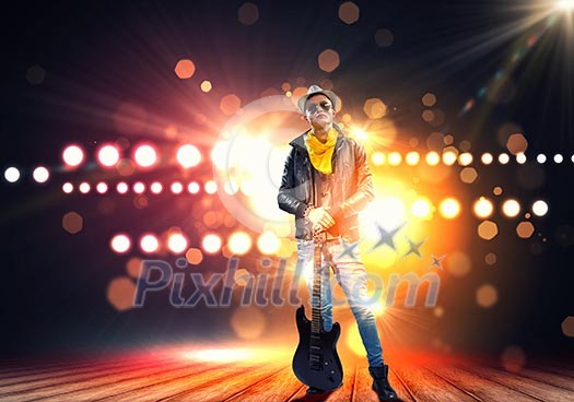 Young man, rock musician in jacket with guitar Young man, rock musician in jacket with guitar