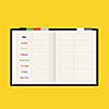 black notebook weekly planner on yellow background
