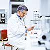 Senior male researcher carrying out scientific research in a lab (shallow DOF; color toned image)