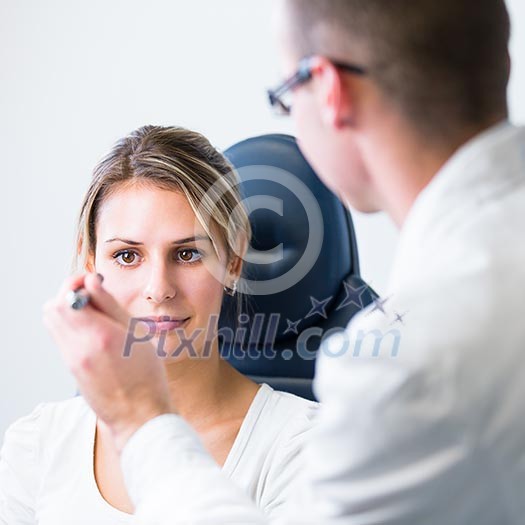 optometry concept - pretty young woman having her eyes examined by an eye doctor optometry concept - pretty young woman having her eyes examined by an eye doctor