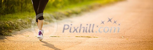 Detail of legs of a female runner on road - jog workout/well-being concept Detail of legs of a female runner on road - jog workout/well-being concept