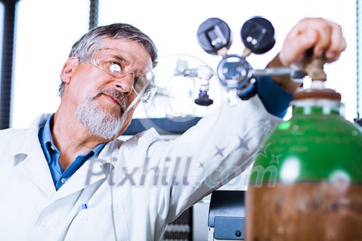 Senior male researcher carrying out scientific research in a lab (shallow DOF; color toned image)