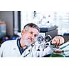 Senior male researcher carrying out scientific research in a lab (shallow DOF; color toned image)