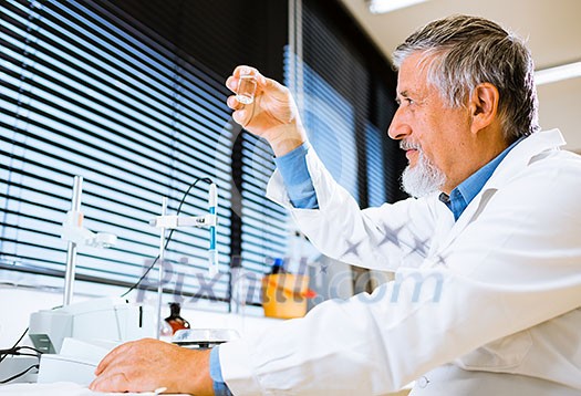 Senior male researcher carrying out scientific research in a lab (shallow DOF; color toned image)