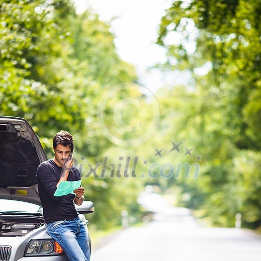 Handsome young man calling for assistance with his car broken down by the roadside