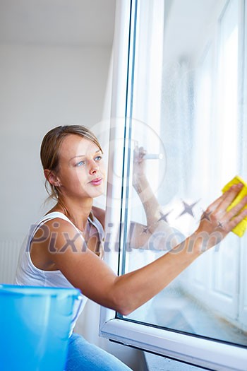 Pretty, young woman doing house work - washing windows (shallow DOF; color toned image)
