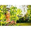 Pretty female gardener taking care of her lovely garden on a lovely spring day - cutting branches, double digging/loosening the soil with a spade