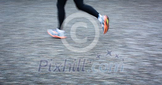 Motion blurred runner's feet in a city environment (panning technique used -> motion blurred image; color toned image)