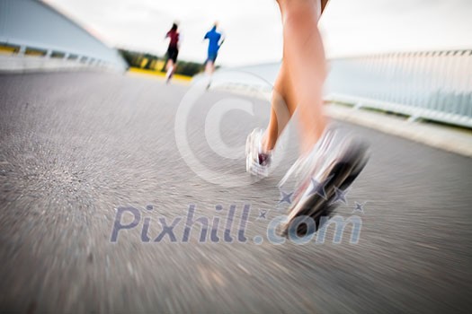 Young woman jogging outdoors (motion blurred image)