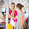 Pretty, young woman on a streetcar/tramway, during her commute to work (color toned image; shallow DOF)