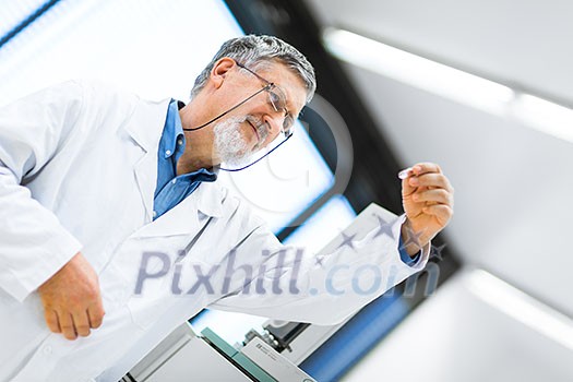 Senior male researcher carrying out scientific research in a lab (shallow DOF; color toned image)