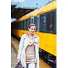 Pretty young woman at a train station (color toned image)