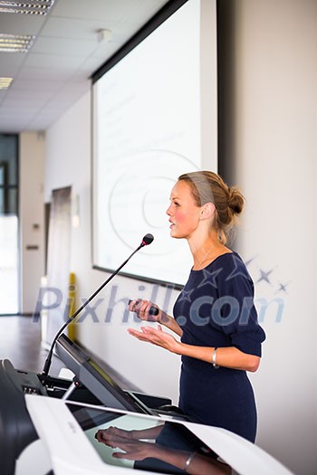 Pretty, young business woman giving a presentation in a conference/meeting setting (shallow DOF; color toned image) Pretty, young business woman giving a presentation in a conference/meeting setting (shallow DOF; color toned image)