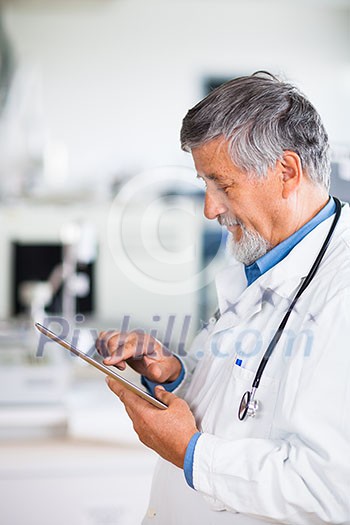 Senior doctor using his tablet computer at work (color toned image) Senior doctor using his tablet computer at work (color toned image)