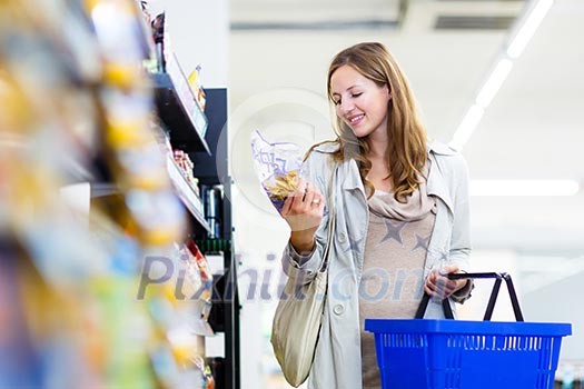 Beautiful young woman shopping in a grocery store/supermarket (color toned image) Beautiful young woman shopping in a grocery store/supermarket (color toned image)