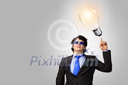 Image of young businessman with light bulb. New idea and inspiration