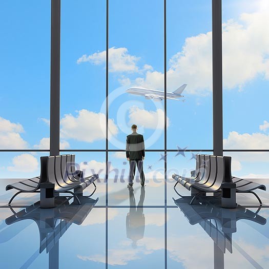 Businessman at airport looking at airplane taking off