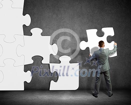 Image of businessman compiling macro white puzzle. Building business Image of businessman compiling macro white puzzle. Building business