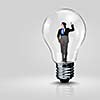 Image of young businessman in light bulb. New idea and inspiration