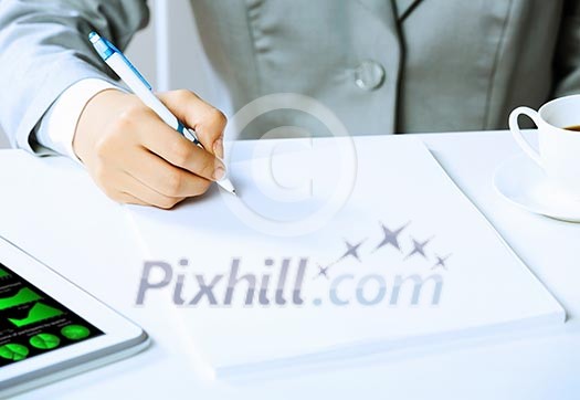 Image of businesswoman sitting at table and drawing sketch