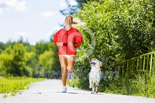 Young attractive sport girl running with dog in park