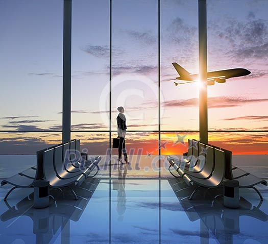 Image of woman in airport looking at taking off airplane Image of woman in airport looking at taking off airplane
