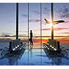 Image of woman in airport looking at taking off airplane