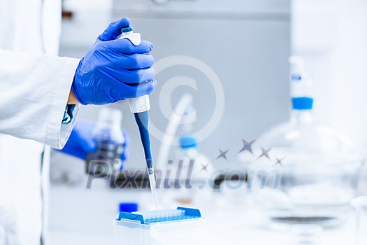 Hands of a researcher carrying out scientific research experiment in a lab (shallow DOF; color toned image)