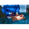 Surgeon performing an operation on a patient in a hospital (shallow DOF; color toned image)
