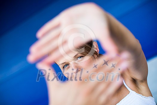 Pretty, young woman making a photo composing/shooting gesture with her hands