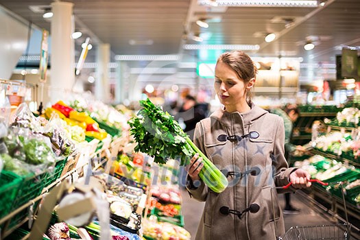 Beautiful young woman shopping for fruits and vegetables in produce department of a grocery store/supermarket Beautiful young woman shopping for fruits and vegetables in produce department of a grocery store/supermarket