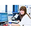 Portrait of a female researcher doing research in a lab (shallow DOF; color toned image)