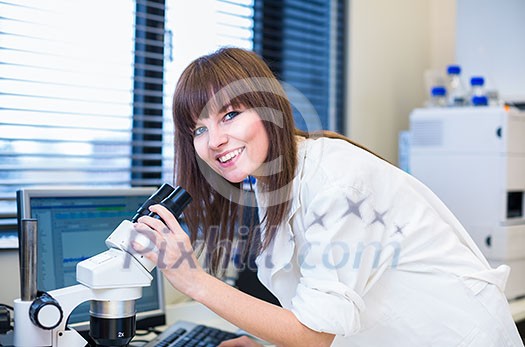 Portrait of a female researcher doing research in a lab (shallow DOF; color toned image)