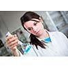 Portrait of a female researcher/chemistry student carrying out research in a chemistry lab (color toned image; shallow DOF)