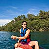 Handsome young man on a canoe on a lake, paddling, enjoying a lovely summer day