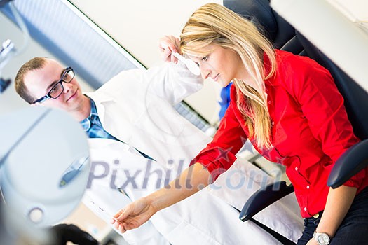 Optometry concept - pretty young woman having her eyes examined by an eye doctor (color toned image; shallow DOF)